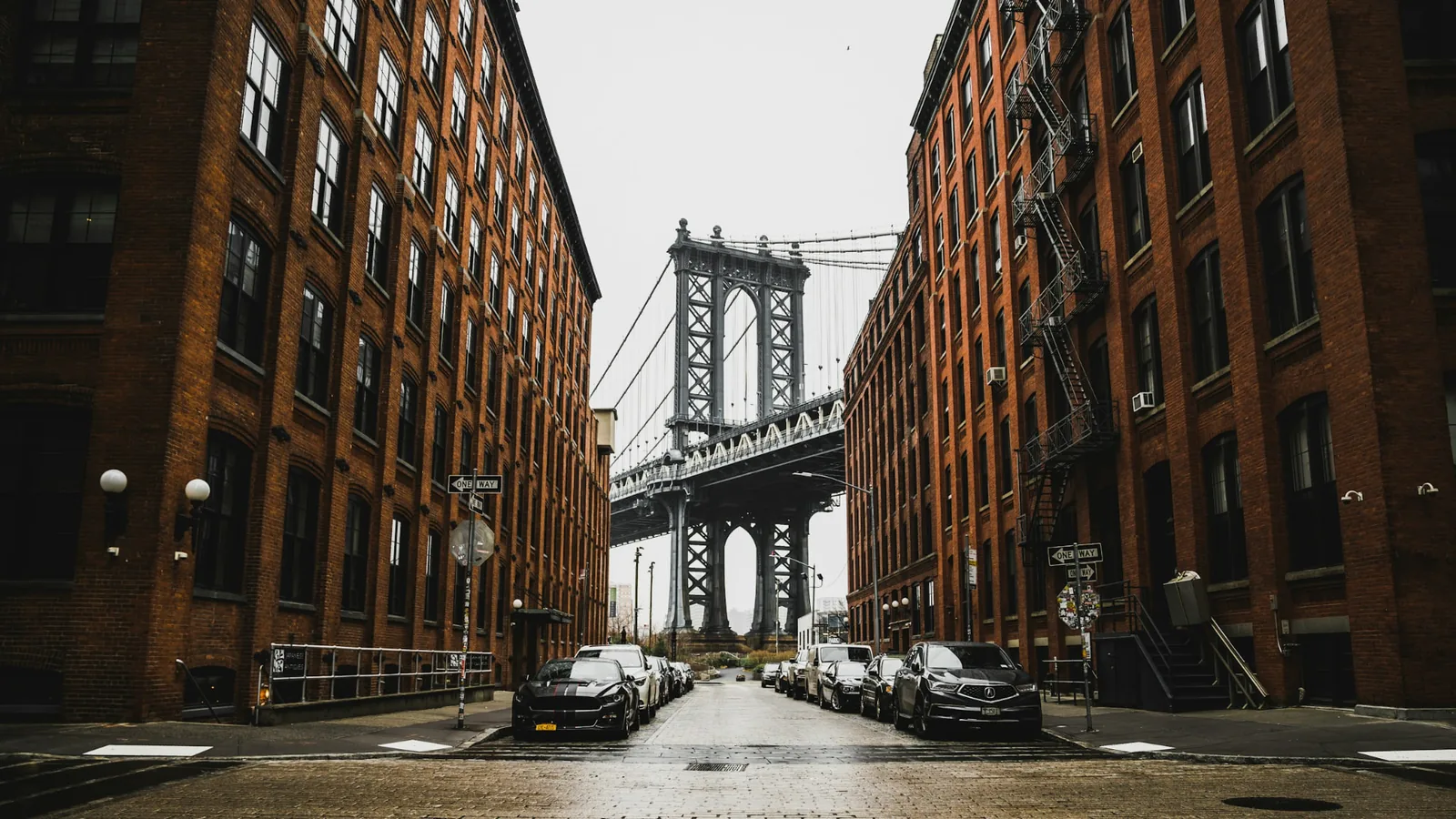 Manhattan Bridge seen between brick buildings in DUMBO, Brooklyn
