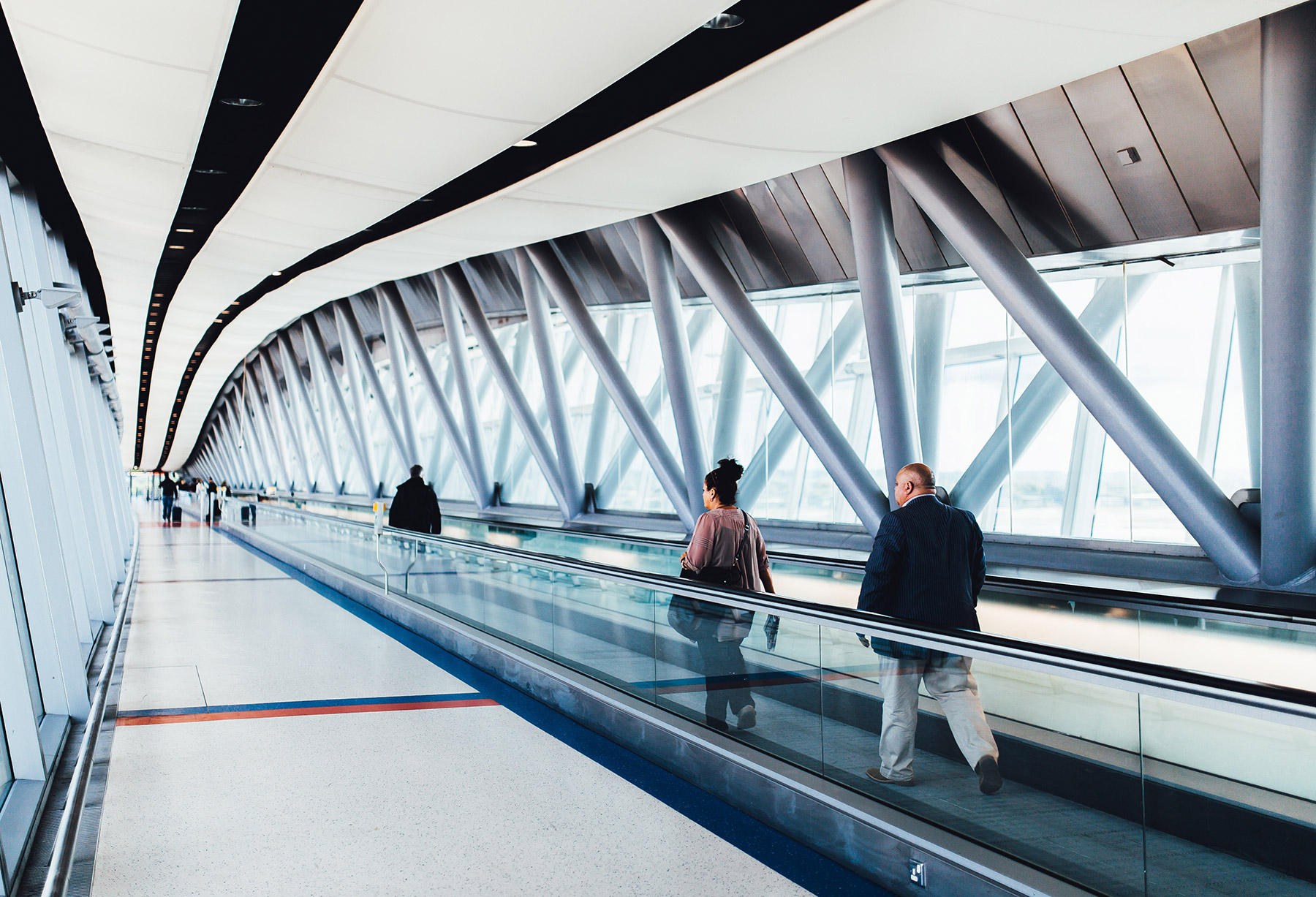 Bright airport walkway with travelers
