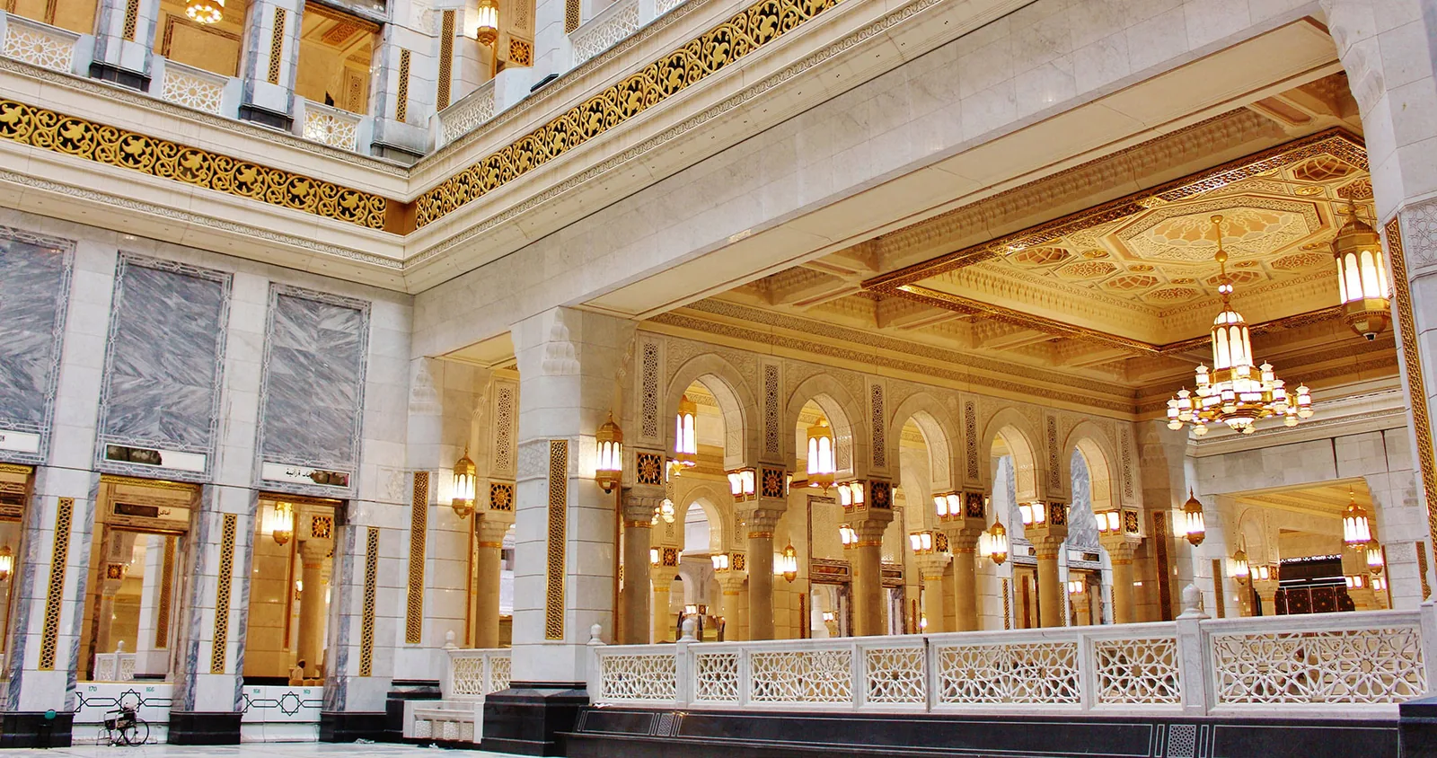 Grand ornate hotel lobby with arched columns and chandeliers