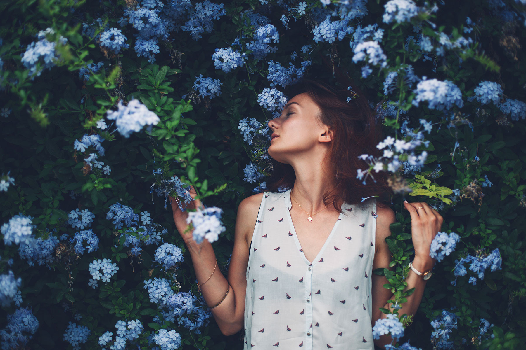 Woman surrounded by fragrant blue flowers
