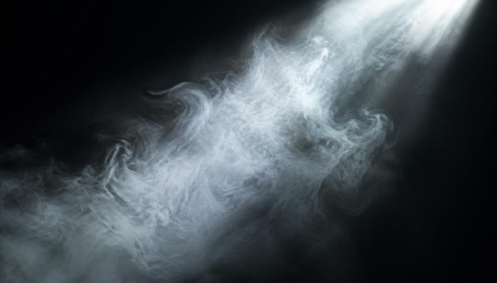 Fine mist drifting through a beam of light